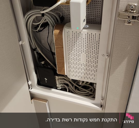 ארון תקשורת עם נתב, כבלים ומפצל חשמל